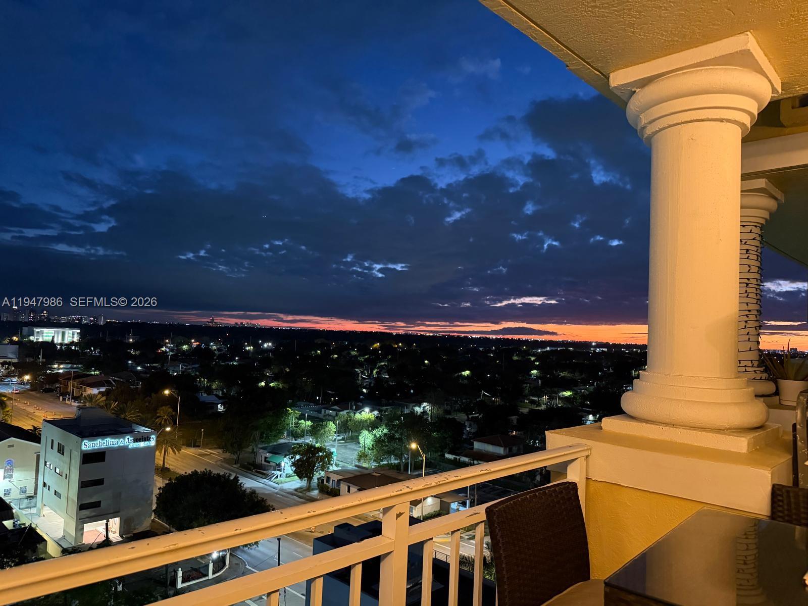 A dining area with a wooden table leads into a living room with a balcony — 215 SW 42nd Ave, Miami FL 33134, MIAMI, FL