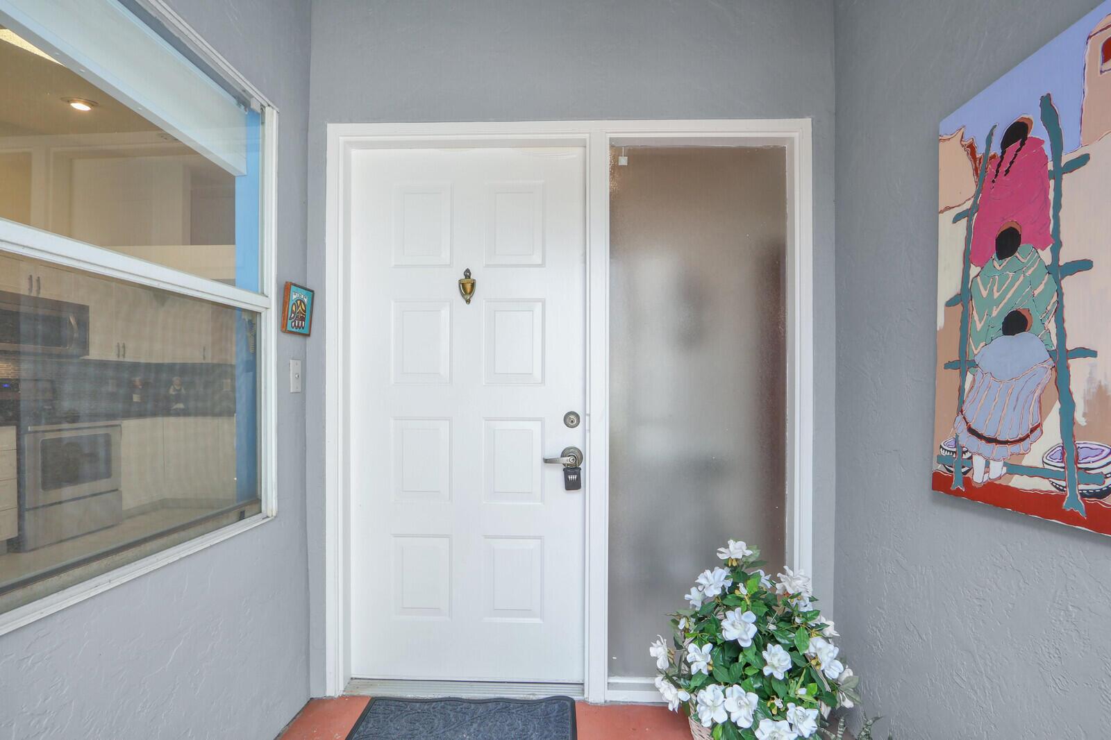 A white front door with a sidelight and a painting on a gray wall — 9904 Summerbrook Terrace # B, Boynton Beach FL 33437, BOYNTON BEACH, FL