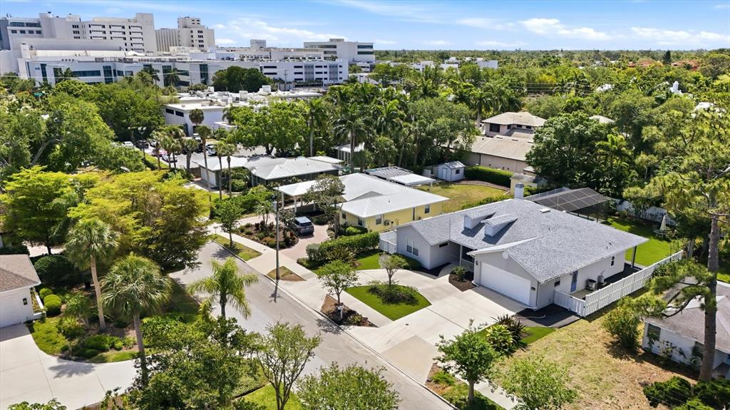 An aerial view shows several single-story residential houses surrounded by trees and paved driveways — 1714 WALDEMERE STREET, SARASOTA, FL