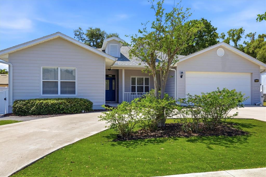 A single-story house with light gray siding, a blue front door, and a two-car garage — 1714 WALDEMERE STREET, SARASOTA, FL