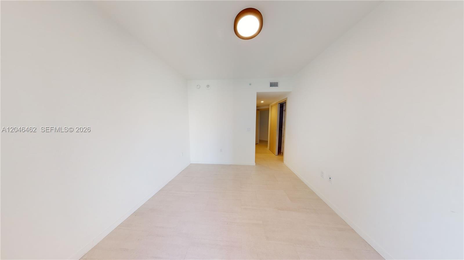 An empty room features white walls, light-colored tile flooring, and a single ceiling light fixture — 1000 Brickell Plaza # 3915, Miami FL 33131, MIAMI, FL