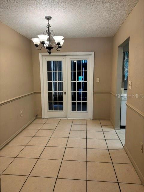 A dining room features tile flooring, a chandelier, and white French doors — 8559 PILGRIM COURT, NEW PORT RICHEY, FL
