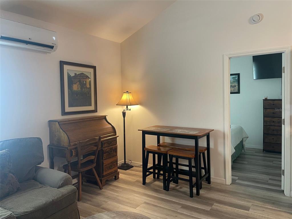 A living area features a roll-top desk, a small dining table, and wood-look flooring — 1484 CLEVELAND STREET, CLEARWATER, FL