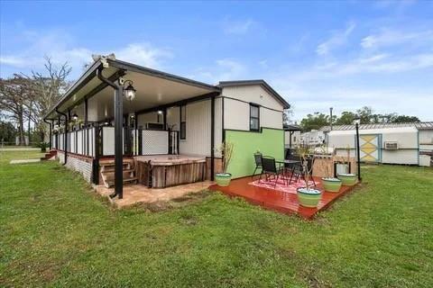 A mobile home features a covered porch with a hot tub and a wooden deck — 4143 SE 29th Court, Okeechobee FL 34974, OKEECHOBEE, FL