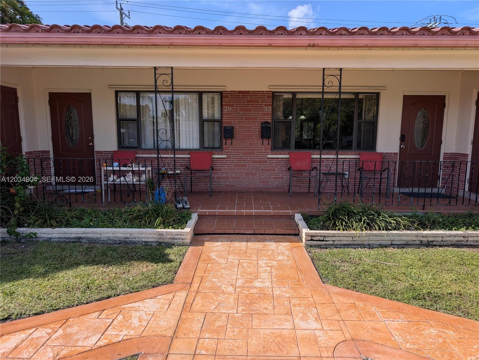 A duplex exterior features a brick facade, tiled porch, and a stamped concrete walkway — 29-33 SE 4th, Dania Beach FL 33004, DANIA BEACH, FL