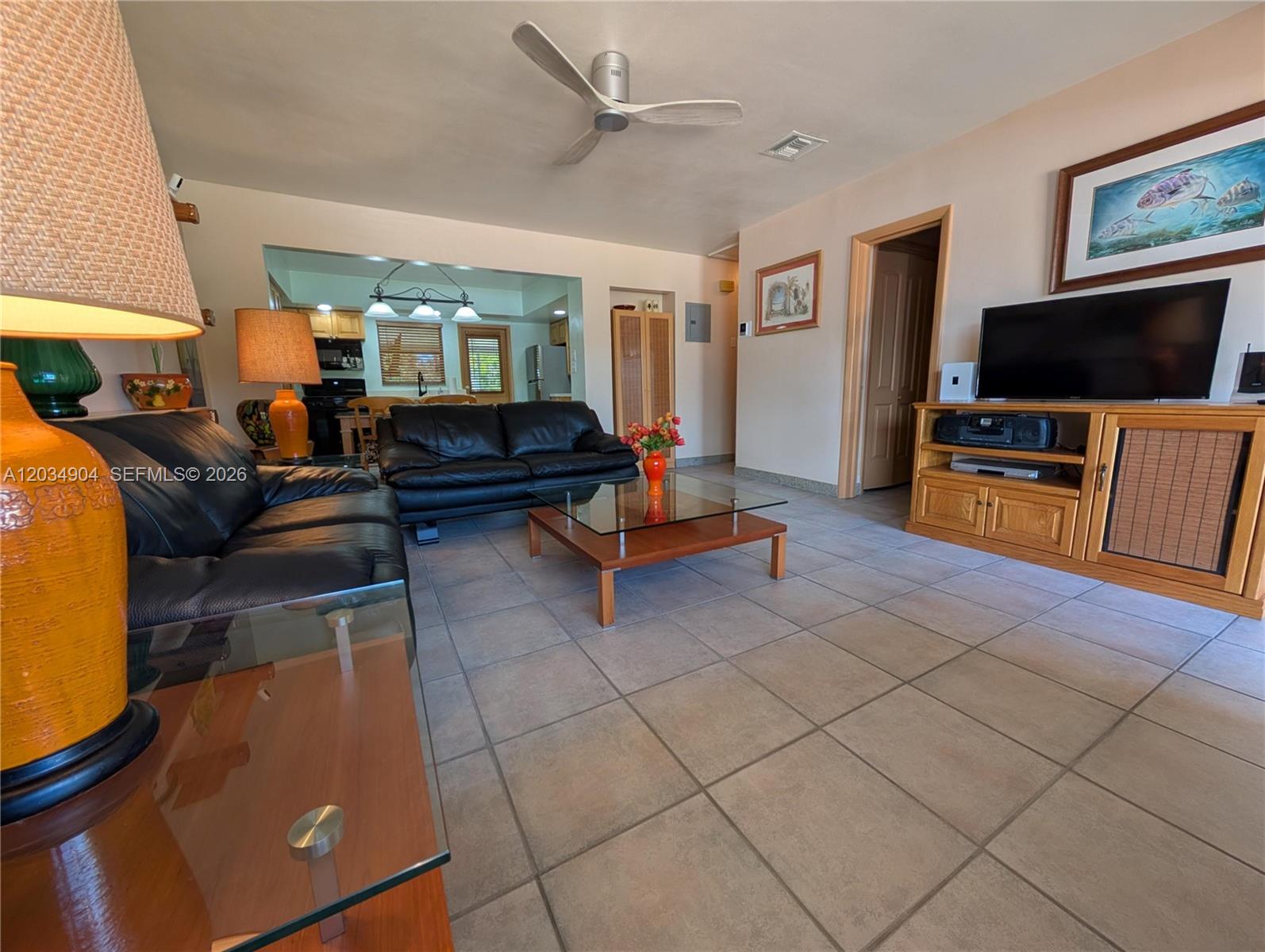 A living room features tile floors, two black leather sofas, and a wooden media console — 29-33 SE 4th, Dania Beach FL 33004, DANIA BEACH, FL