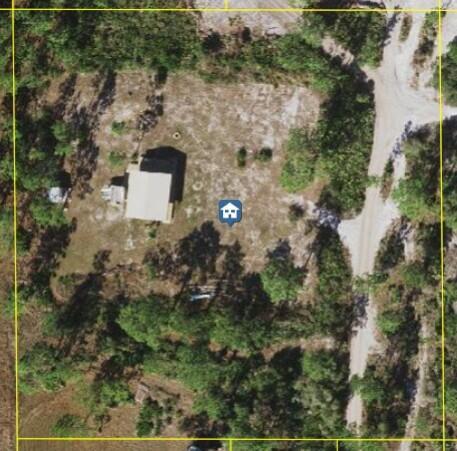 This is an aerial view of a house situated on a wooded lot — 0 Holopaw Groves Road, FL 34771, FL