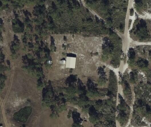 An aerial view shows a rectangular building on a cleared lot surrounded by trees — 0 Holopaw Groves Road, FL 34771, FL
