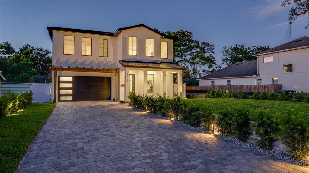 A two-story modern house features a paved driveway, a garage, and exterior landscape lighting — 1523 MILLER AVENUE, WINTER PARK, FL