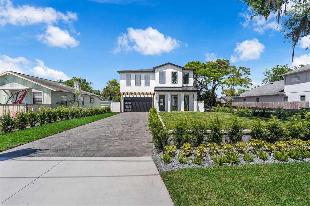 A modern two-story house with a paved driveway and landscaped front yard under a blue sky — 1523 MILLER AVENUE, WINTER PARK, FL