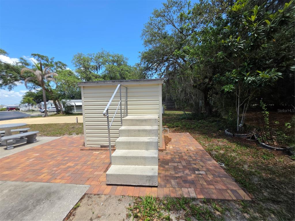 A set of concrete stairs with a metal handrail leads to a small shed — 7371 INTERNATIONAL CIRCLE, LAKE WALES, FL