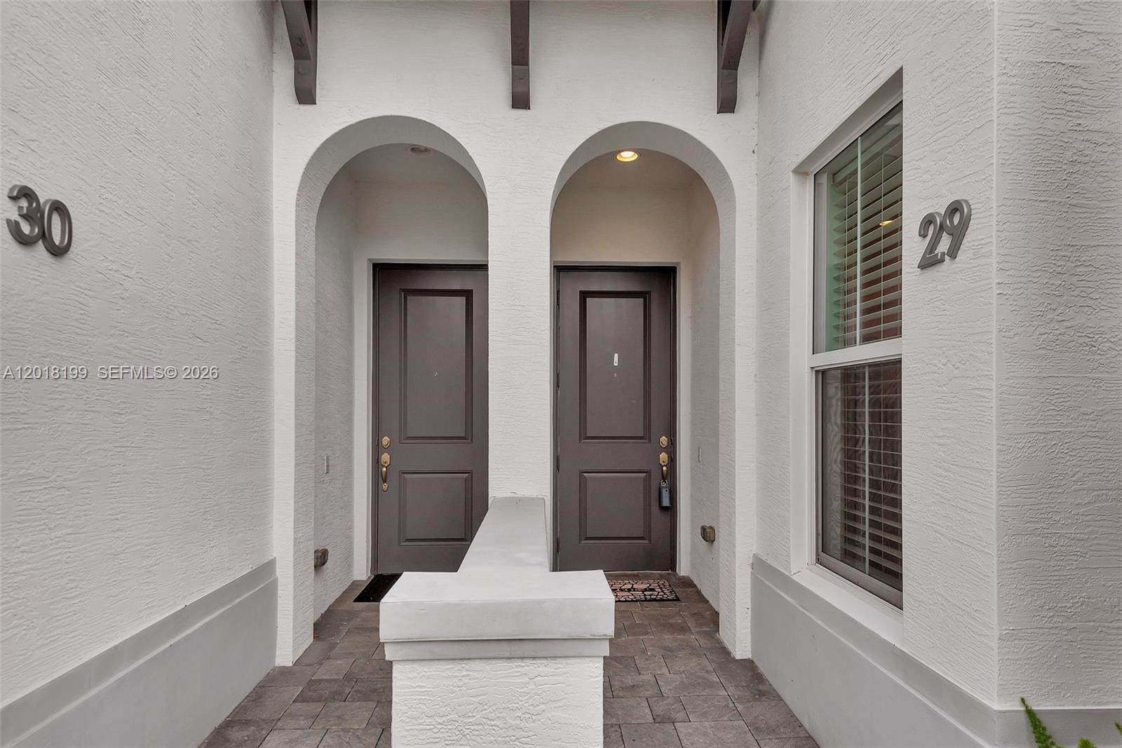 Two dark gray front doors are set within arched alcoves of a white stucco building — 22954 Clear Echo Dr # 29, Boca Raton FL 33433, BOCA RATON, FL
