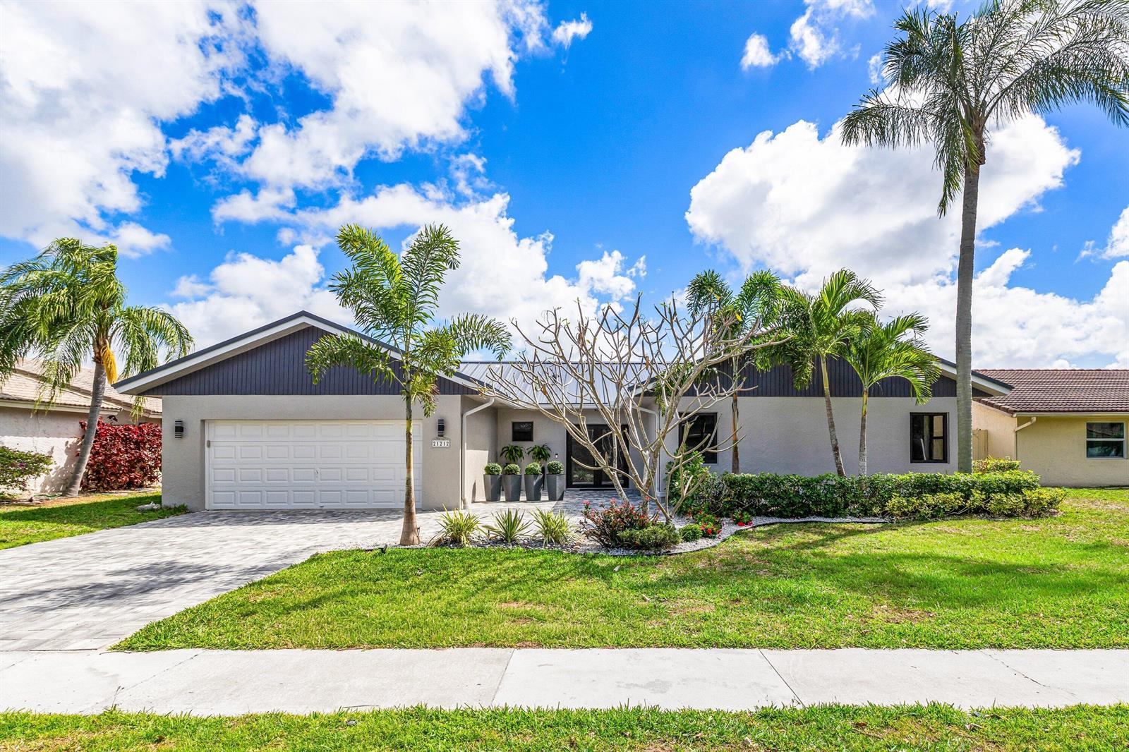 A single-story house with a white garage, gray siding, and palm trees in the front yard — 21212 Escondido Way, Boca Raton FL 33433, BOCA RATON, FL