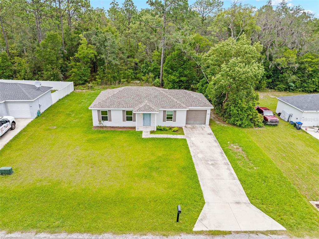 An aerial view of a single-story suburban house with a concrete driveway and grassy yard — 2549 W CASTANIA DRIVE, CITRUS SPRINGS, FL