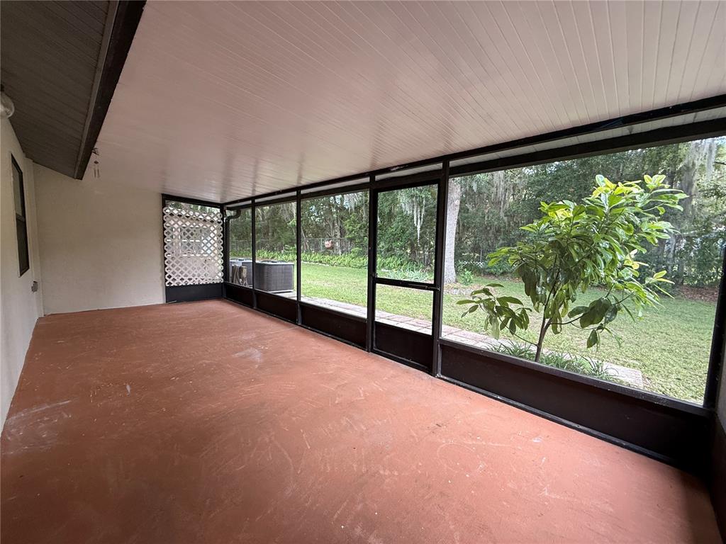 A screened-in porch with a painted concrete floor, white ceiling, and views of the yard — 517 WHISPERING PINES BOULEVARD, INVERNESS, FL