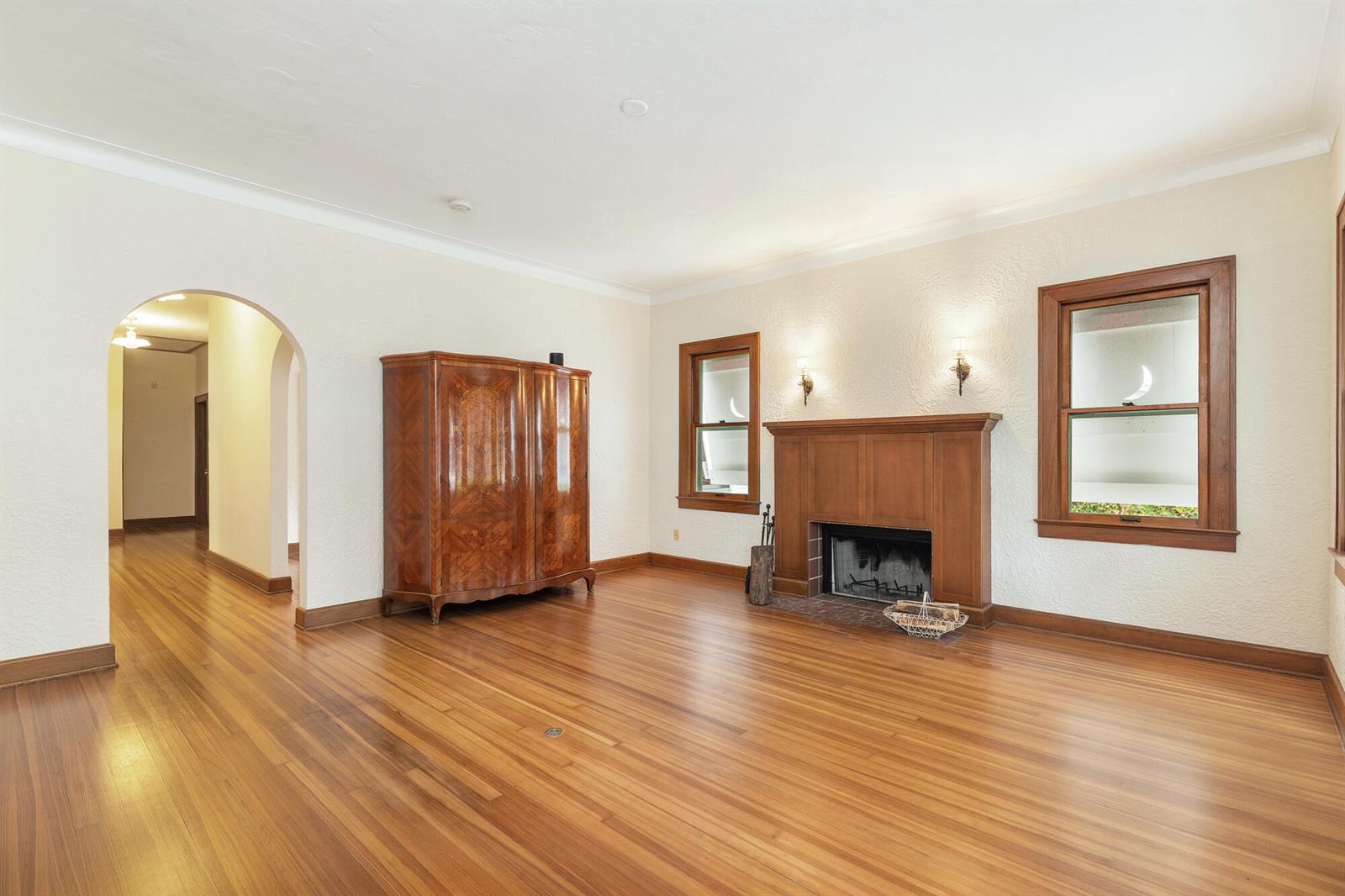 A living room features hardwood floors, a wooden fireplace mantel, and an arched doorway — 800 Kanuga Drive, West Palm Beach FL 33401, WEST PALM BEACH, FL
