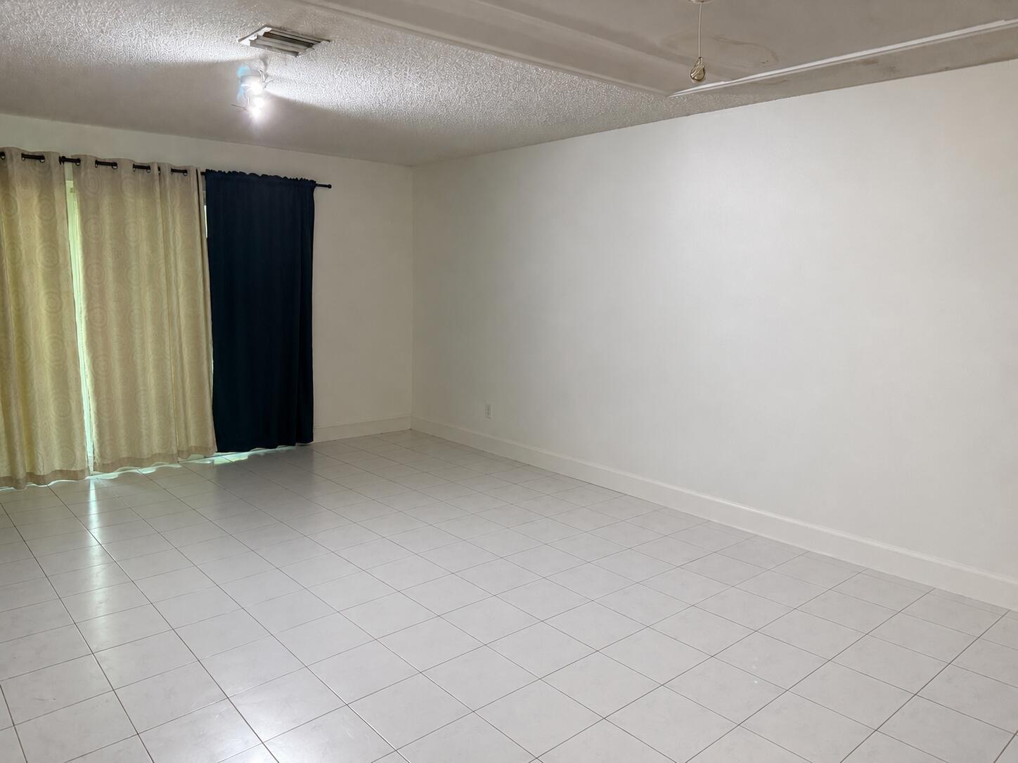 An empty room with white walls, white tile flooring, and a sliding glass door — 12272 NW 36th Place, Sunrise FL 33323, SUNRISE, FL