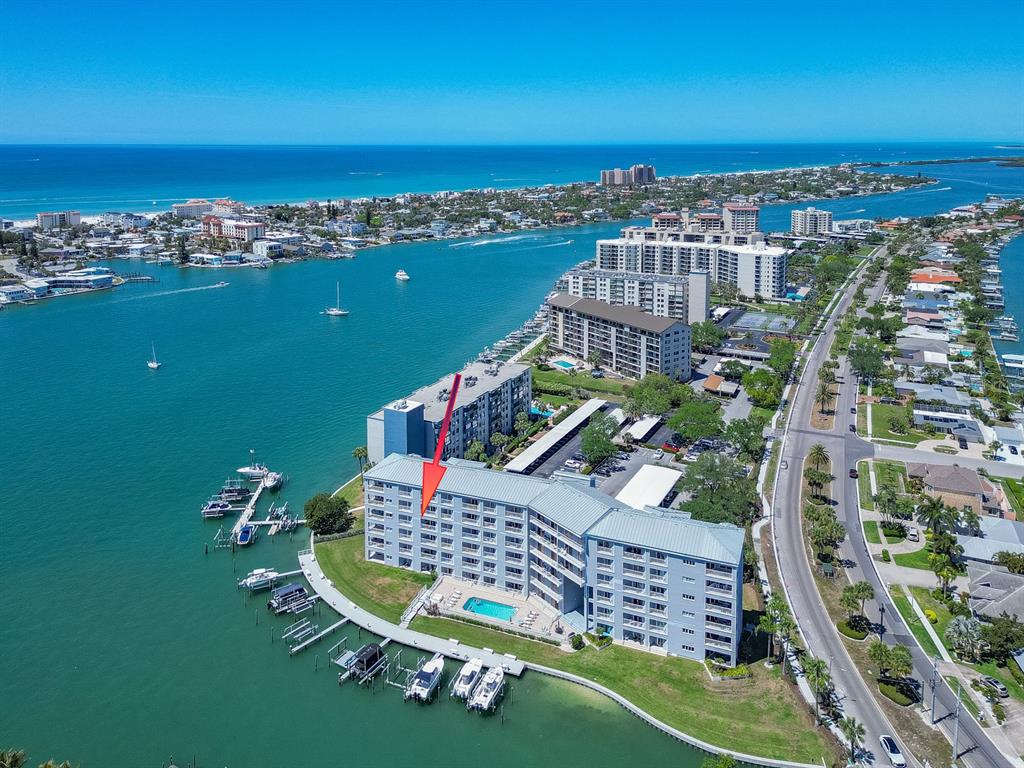 An aerial view of a waterfront condominium complex with a pool and boat docks — 610 ISLAND WAY UNIT 407, CLEARWATER BEACH, FL