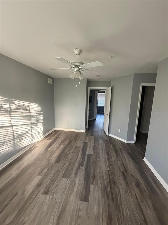 An empty room features light gray walls, wood-look flooring, and a ceiling fan — 7250 WESTPOINTE BOULEVARD UNIT 1034, ORLANDO, FL