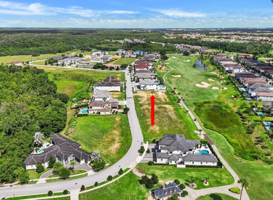 An aerial view shows a vacant residential lot next to a golf course and houses — 1153 GRAND TRAVERSE PARKWAY, REUNION, FL