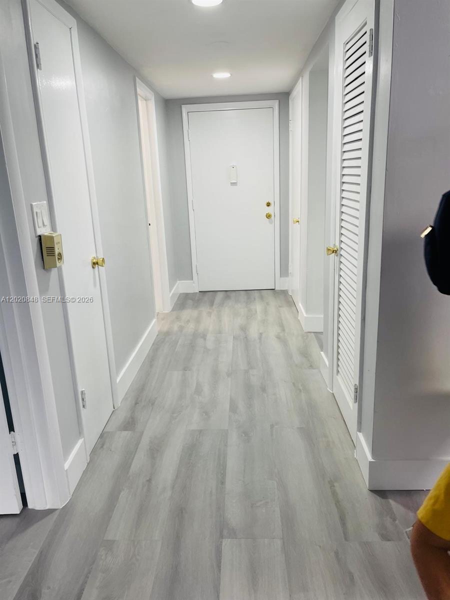 A hallway features light gray wood-look flooring, white walls, and several white interior doors — 9175 SW 77th Ave # 306, Miami FL 33156, MIAMI, FL