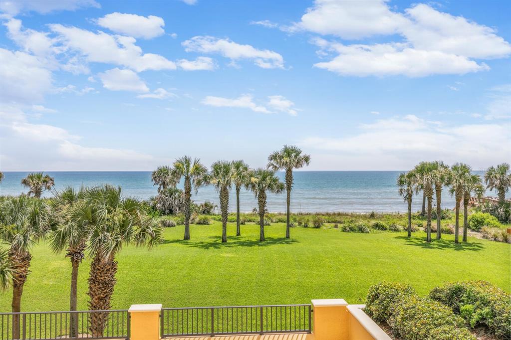 A view of a grassy lawn with palm trees overlooking the ocean under a blue sky — 20 PORTO MAR UNIT 202, PALM COAST, FL