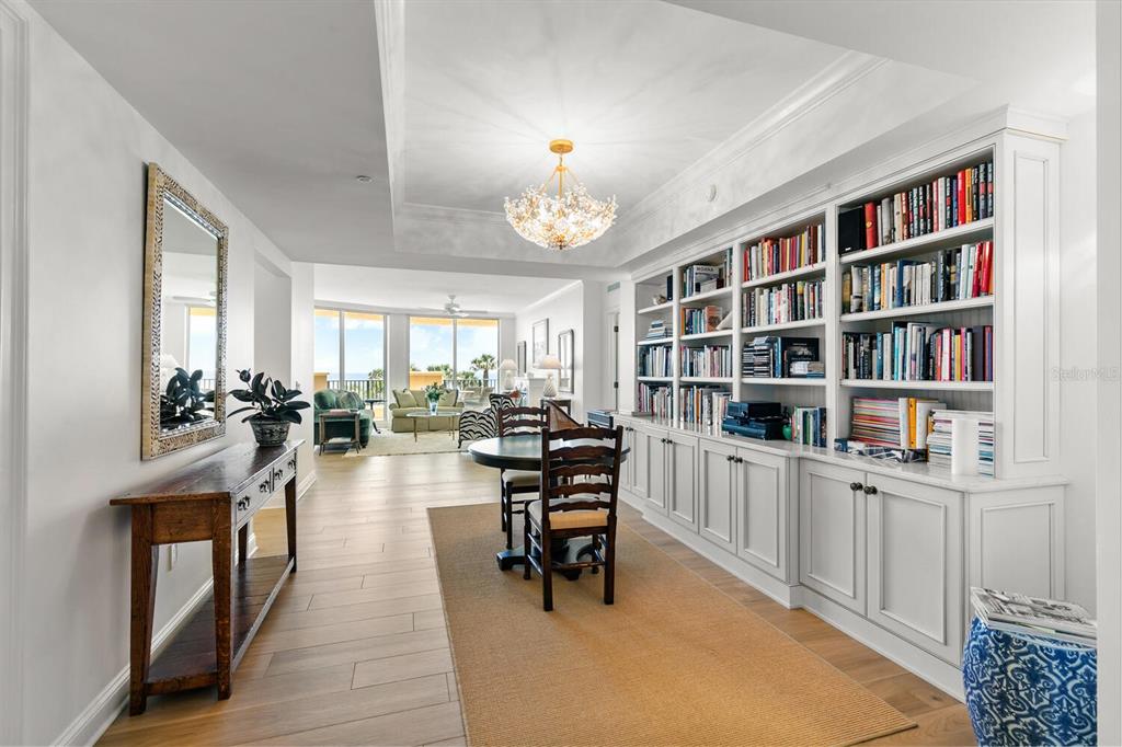 A dining area with a built-in bookshelf, chandelier, and a view of the ocean — 20 PORTO MAR UNIT 202, PALM COAST, FL