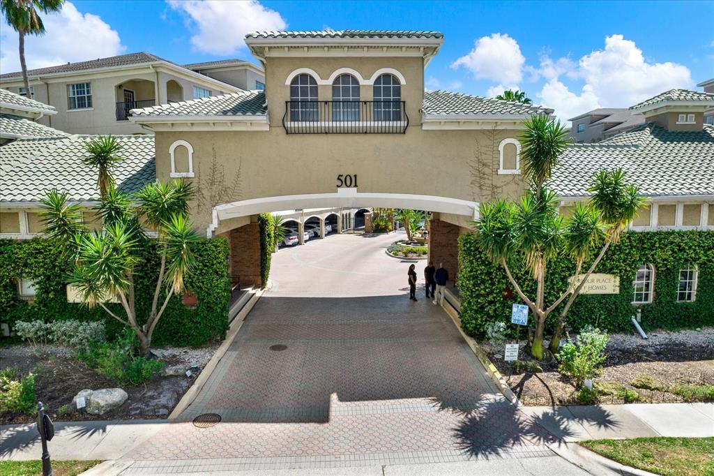 An arched entryway leads into a residential complex with a central tower and landscaping — 501 KNIGHTS RUN AVE UNIT 1234, TAMPA, FL
