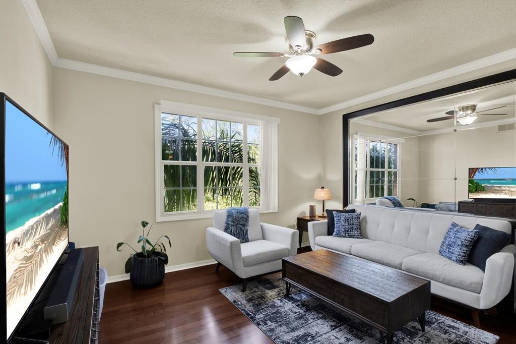 A living room features a white sofa, an armchair, a coffee table, and a mirrored wall — 501 KNIGHTS RUN AVE UNIT 1234, TAMPA, FL
