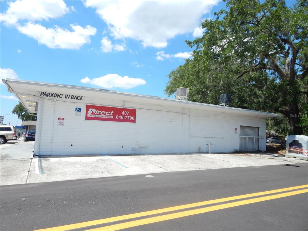 The exterior of a white commercial building features a Direct Auto & Life Insurance sign — 1503 N MAIN STREET, KISSIMMEE, FL
