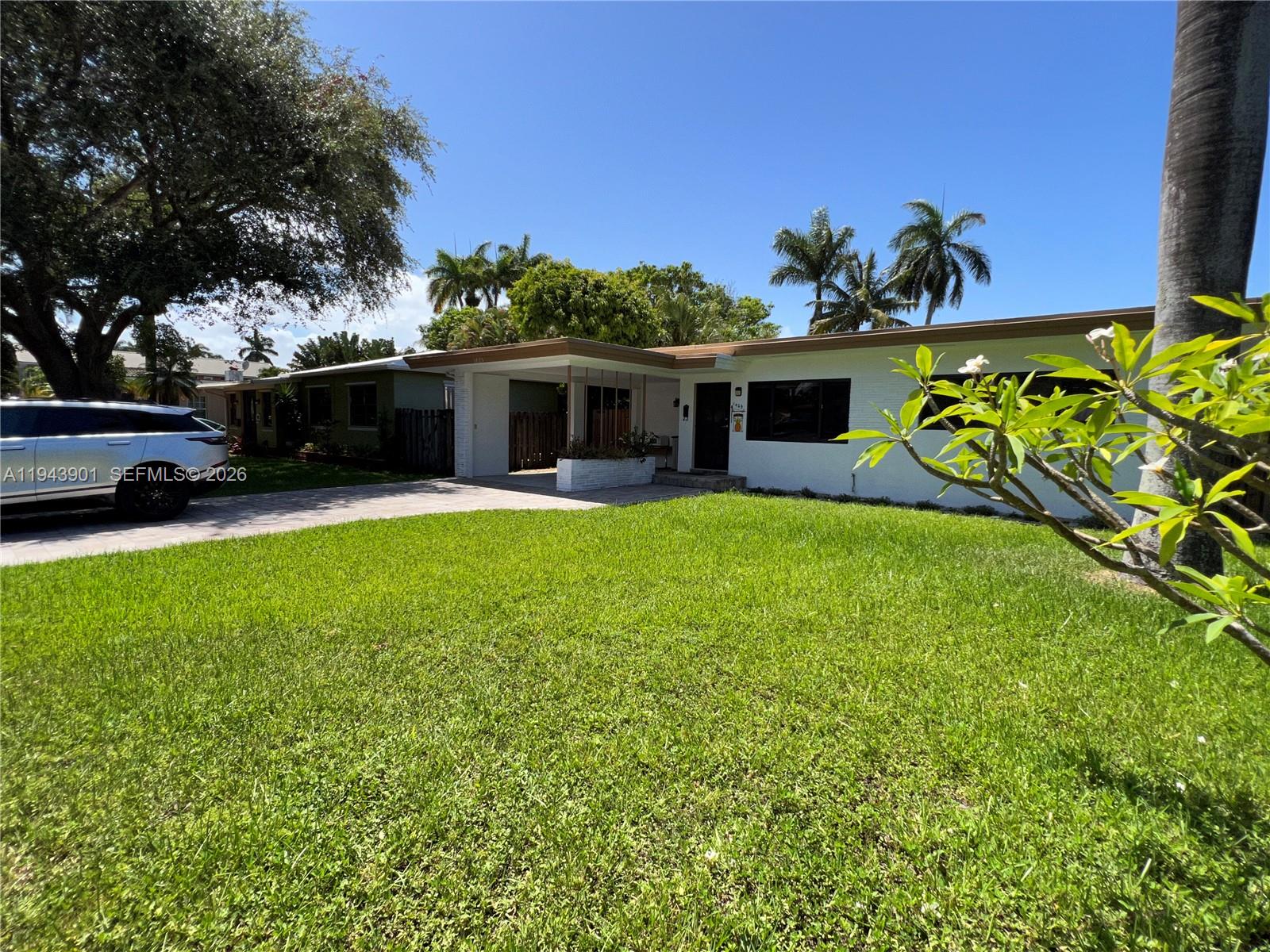 A single-story white house features a flat roof, a carport, and a grassy front lawn — 1425 Grant St, Hollywood FL 33020, HOLLYWOOD, FL