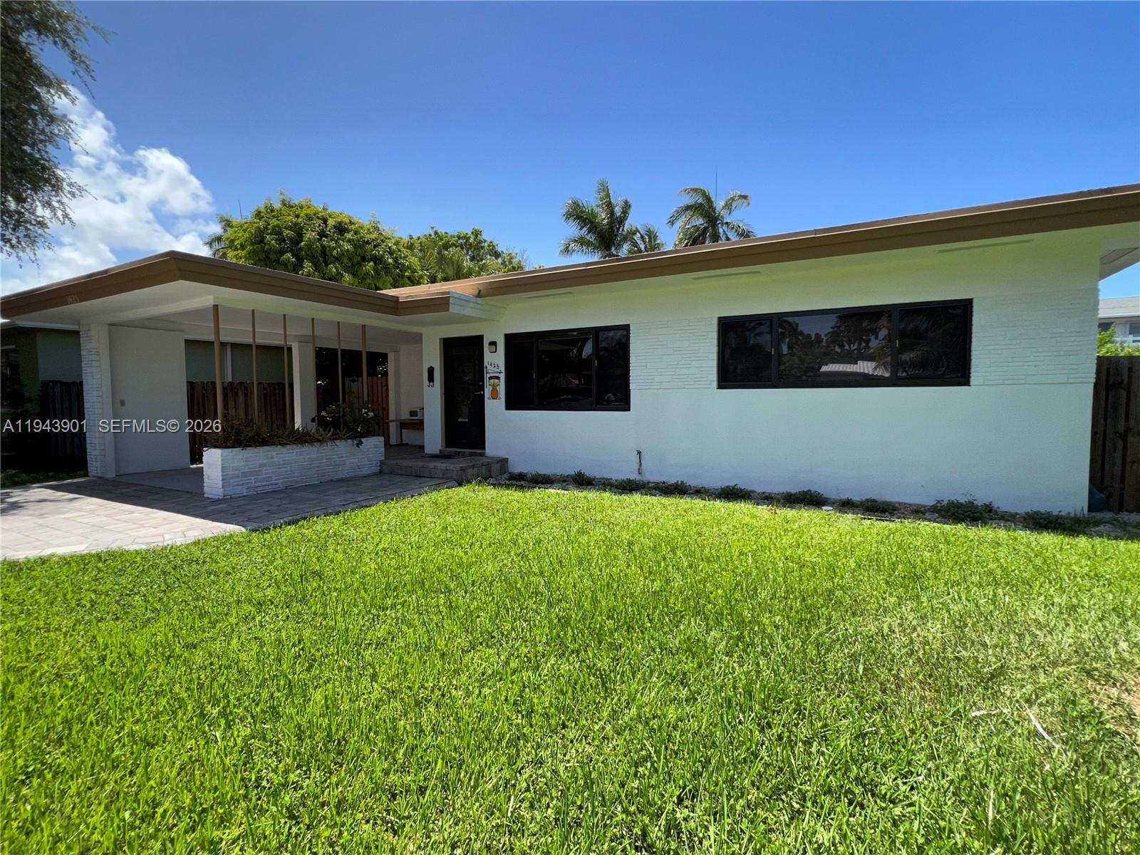 A white, single-story house features a flat roof, a carport, and a front lawn — 1425 Grant St, Hollywood FL 33020, HOLLYWOOD, FL