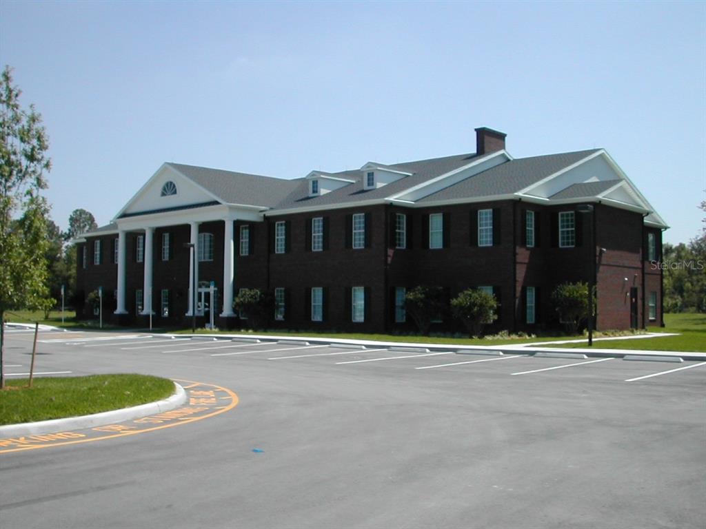 A two-story brick commercial building with a white columned portico and a parking lot — 2461 W STATE ROAD 426 UNIT 1021, OVIEDO, FL