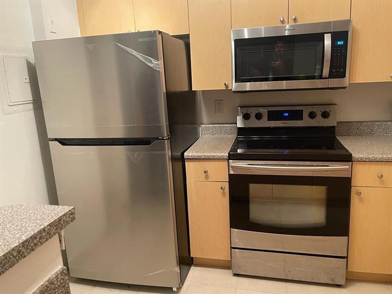 A kitchen features stainless steel appliances, light wood cabinets, and speckled countertops — 2160 E Preserve Way # 201, Miramar FL 33025, MIRAMAR, FL