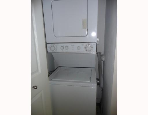 A white stacked washer and dryer unit is installed in a small laundry closet — 2160 E Preserve Way # 201, Miramar FL 33025, MIRAMAR, FL