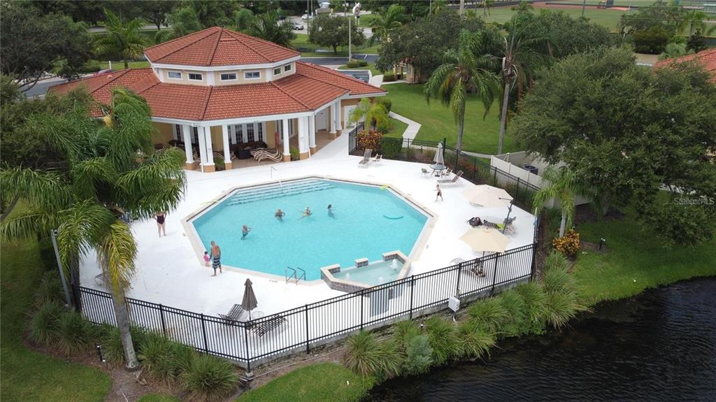 An aerial view of a community clubhouse with an octagonal pool and a red-tiled roof — 1040 VILLAGIO CIRCLE UNIT 201, SARASOTA, FL