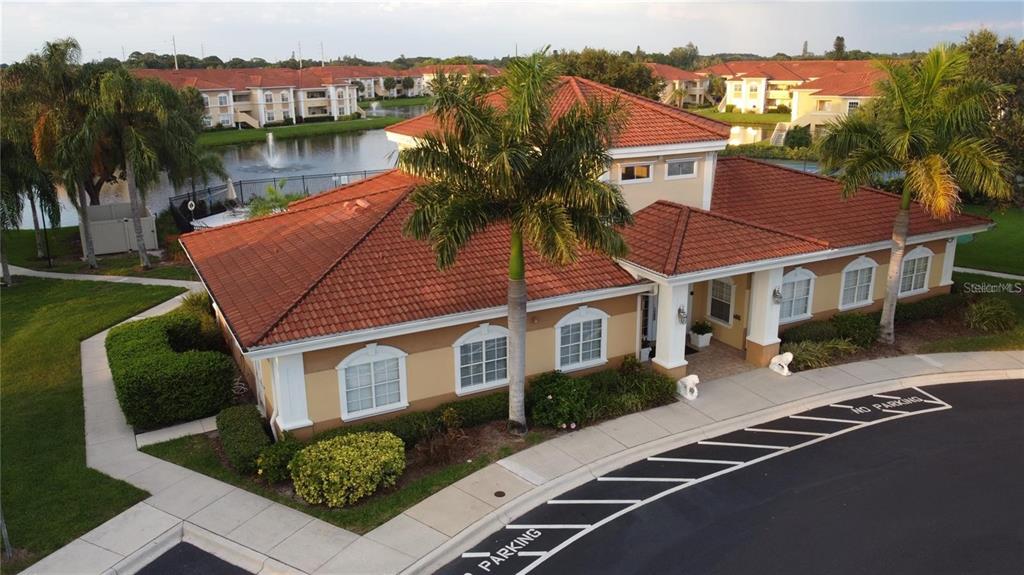 An aerial view of a community clubhouse with a red tile roof and palm trees — 1040 VILLAGIO CIRCLE UNIT 201, SARASOTA, FL