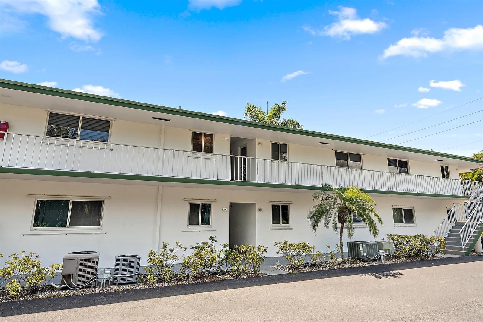 A two-story apartment building with a white exterior, green trim, and an open balcony — 2 Garden Street # 203m, Tequesta FL 33469, TEQUESTA, FL