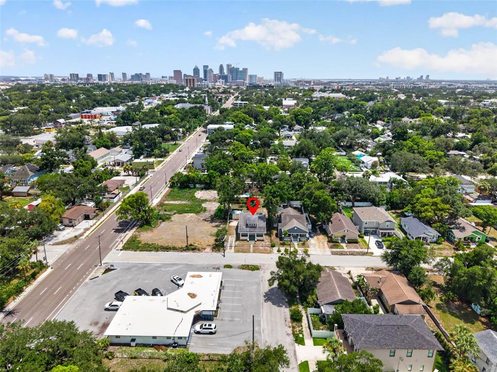 An aerial view shows a residential property marked with a red pin near a city — 104 W 26TH AVENUE, TAMPA, FL