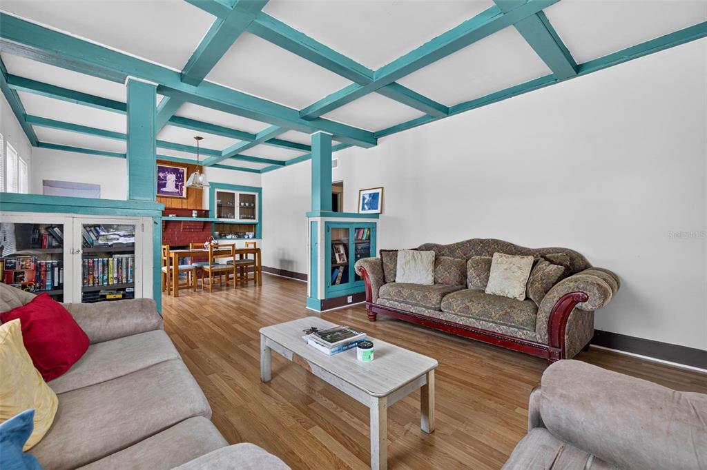 A living room features a teal coffered ceiling, wood flooring, and a patterned sofa — 104 W 26TH AVENUE, TAMPA, FL