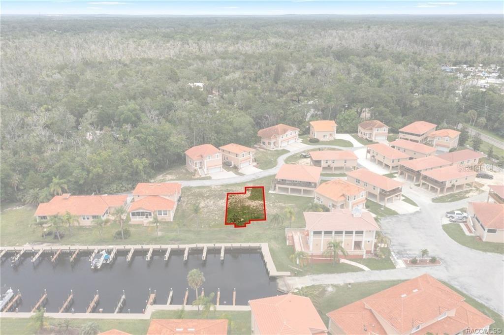 An aerial view shows a vacant waterfront lot outlined in red near a boat dock — 4794 S POLDERLAND WAY, HOMOSASSA, FL