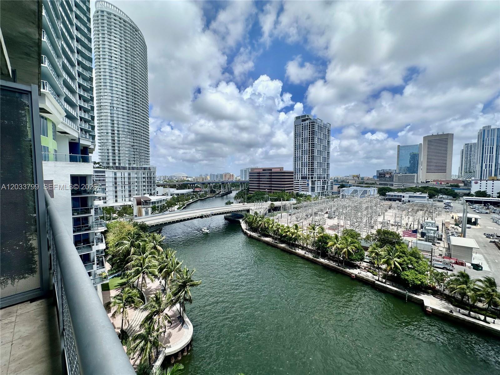 An elevated view shows a river flowing past a power substation and urban high-rise buildings — 690 SW 1st Ct # 1213, Miami FL 33130, MIAMI, FL