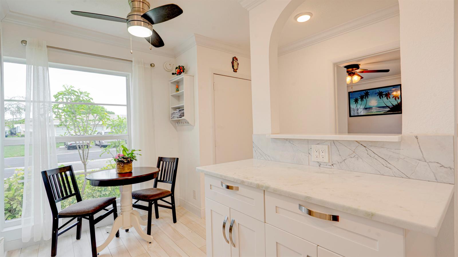 A bright kitchen breakfast nook features a small table, two chairs, and white cabinetry — 8638 Bella Vista Drive, Boca Raton FL 33433, BOCA RATON, FL