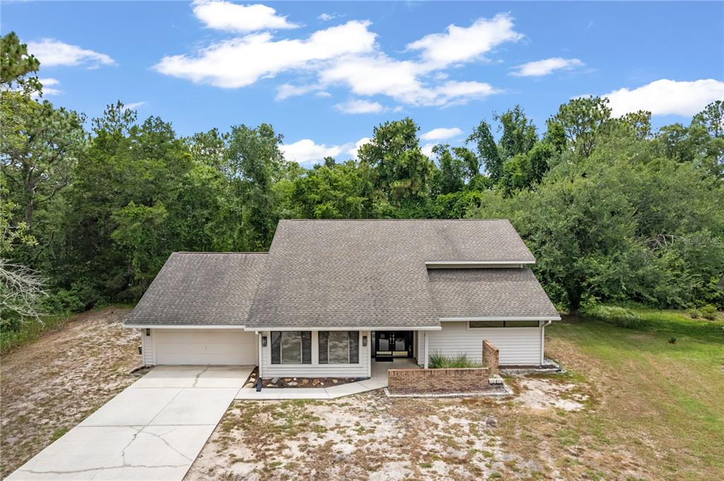 An aerial view of a single-story house with a shingled roof and attached garage — 10 SYCAMORE COURT S, HOMOSASSA, FL