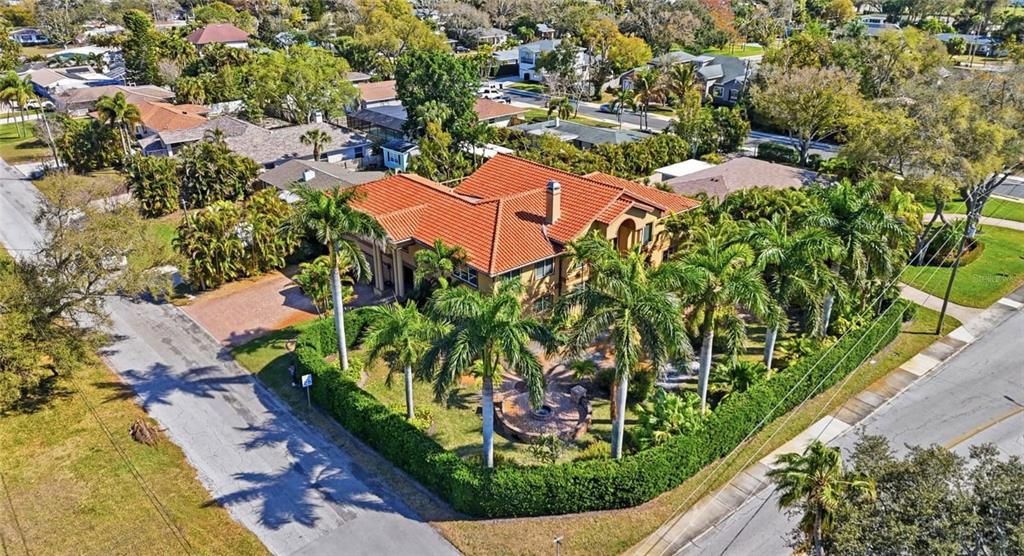 An aerial view of a two-story house with a red tile roof and palm trees — 303 SUNNY LANE, BELLEAIR, FL