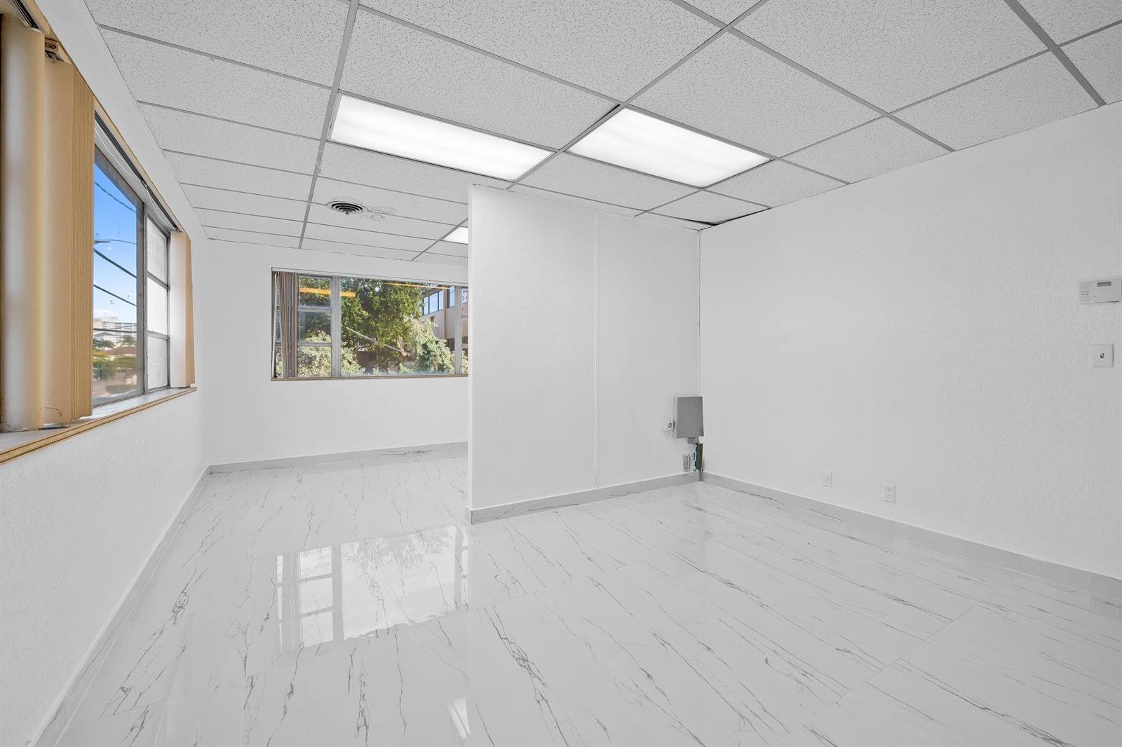 An empty office space with white walls, marble-look tile flooring, and a drop ceiling — 2601 E Atlantic Boulevard, Pompano Beach FL 33062, POMPANO BEACH, FL