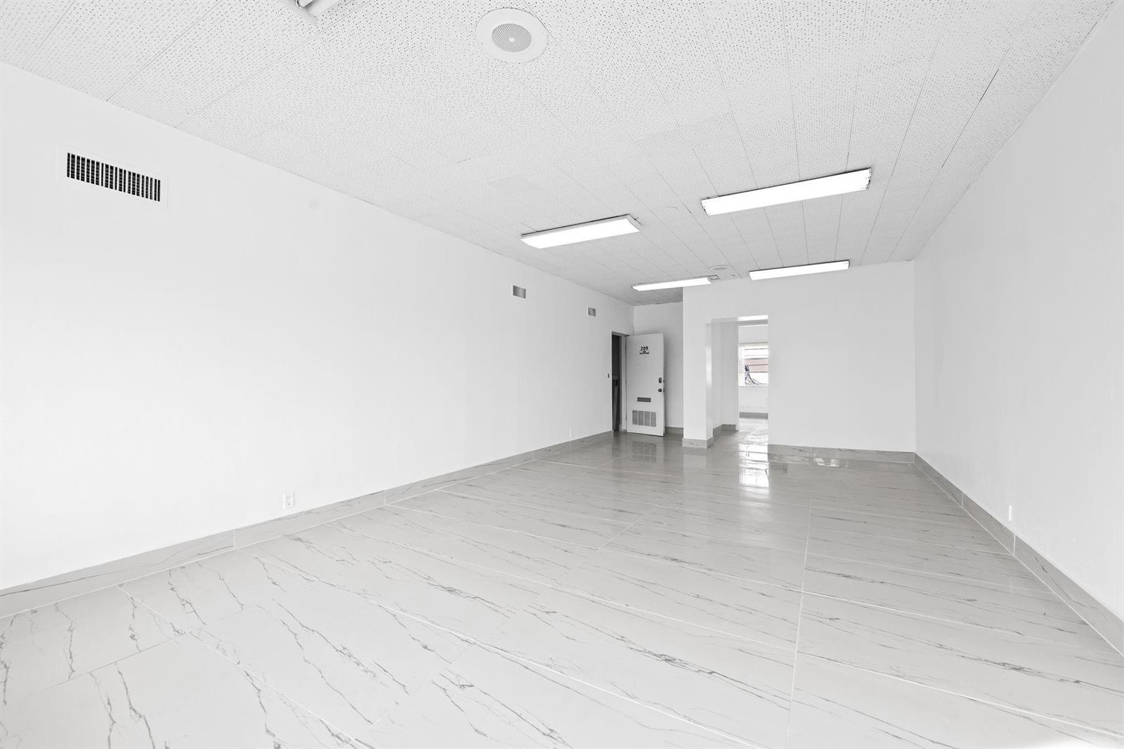 An empty office space with white walls, a drop ceiling, and light-colored marble-patterned tile flooring — 2601 E Atlantic Boulevard, Pompano Beach FL 33062, POMPANO BEACH, FL