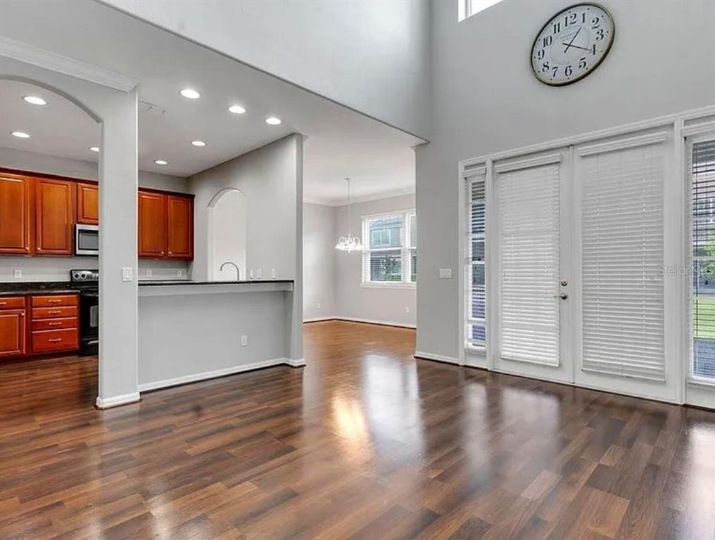 A living area with hardwood floors, a kitchen with wood cabinets, and a wall clock — 2286 CHATHAM PLACE DRIVE, ORLANDO, FL
