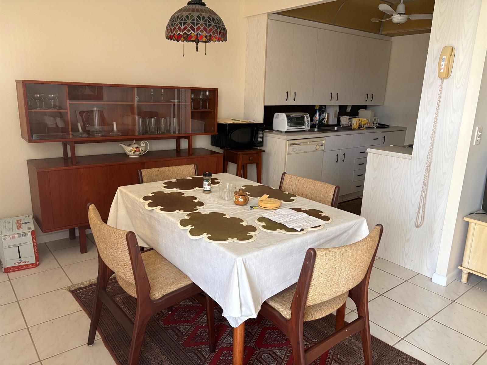 A dining area with a wooden hutch, table with placemats, and an adjacent kitchen — 2036 Cornwall B # 2036, Boca Raton FL 33434, BOCA RATON, FL