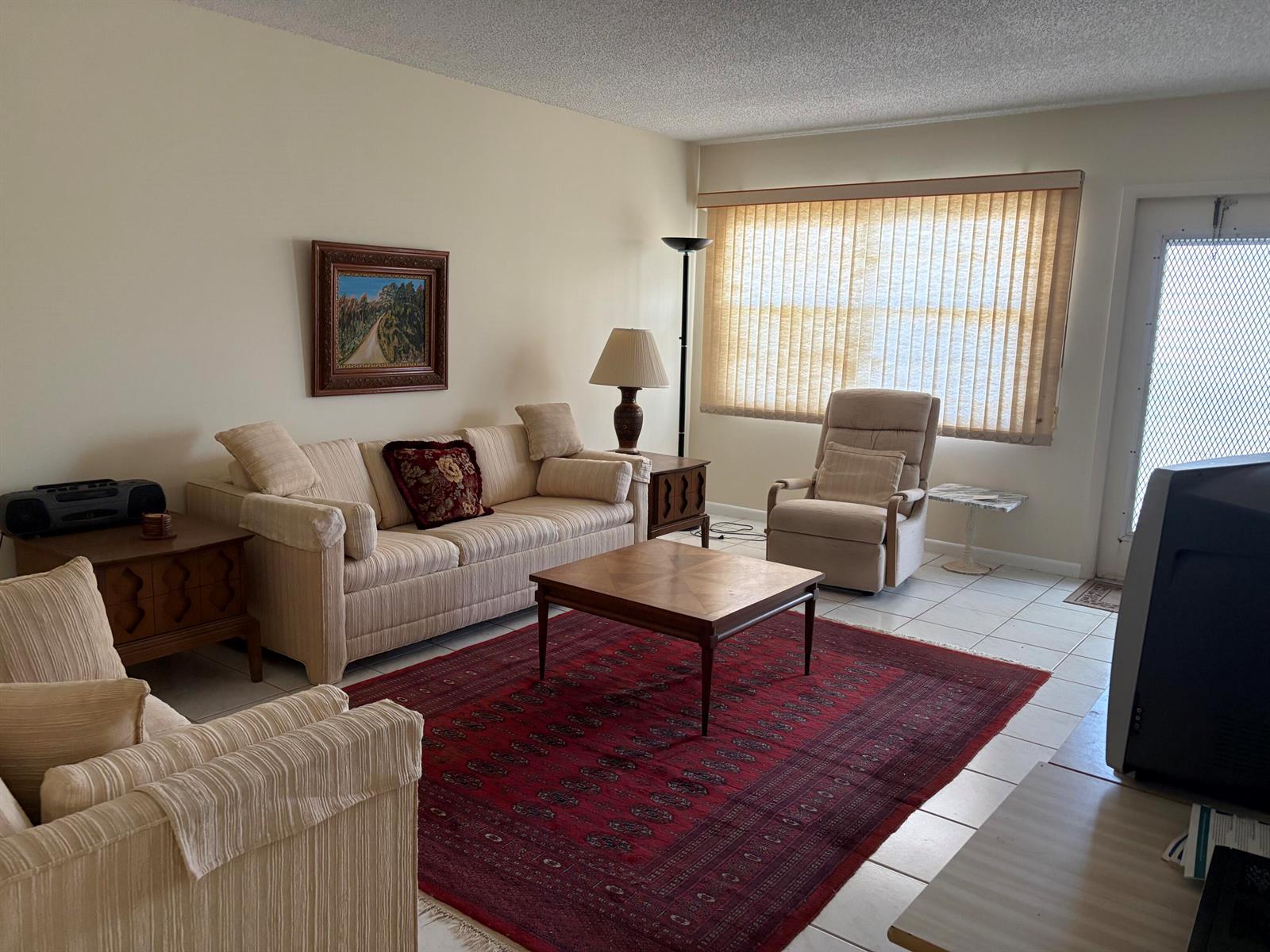 A living room features a beige sofa, a recliner, a coffee table, and a red rug — 2036 Cornwall B # 2036, Boca Raton FL 33434, BOCA RATON, FL